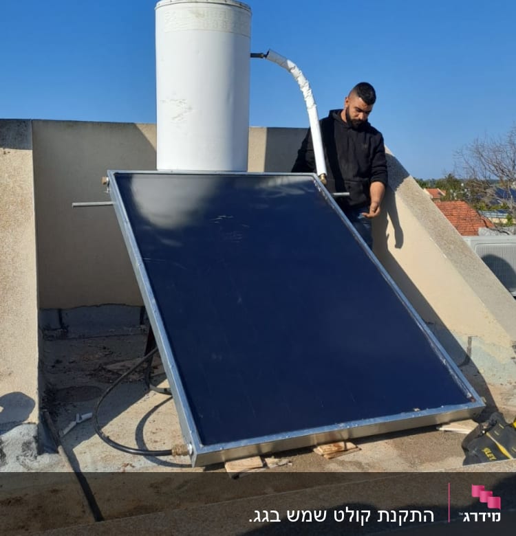 דוד שמש עם קולטן על גג, אדם לידו